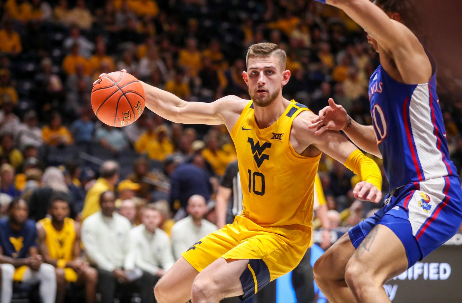 Jan 7, 2023; Morgantown, West Virginia, USA; West Virginia Mountaineers guard Erik Stevenson (10) drives baseline against Kansas Jayhawks forward Jalen Wilson (10) during the first half at WVU Coliseum. Mandatory Credit: Ben Queen-USA TODAY Sports